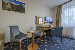 Küçük bir masa ve çalışma masası bulunan otel odası